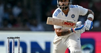 "Virat Kohli raising his bat in celebration after completing 27,000 international runs during a Test match against Bangladesh in September 2024."