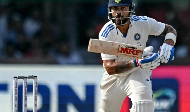 "Virat Kohli raising his bat in celebration after completing 27,000 international runs during a Test match against Bangladesh in September 2024."